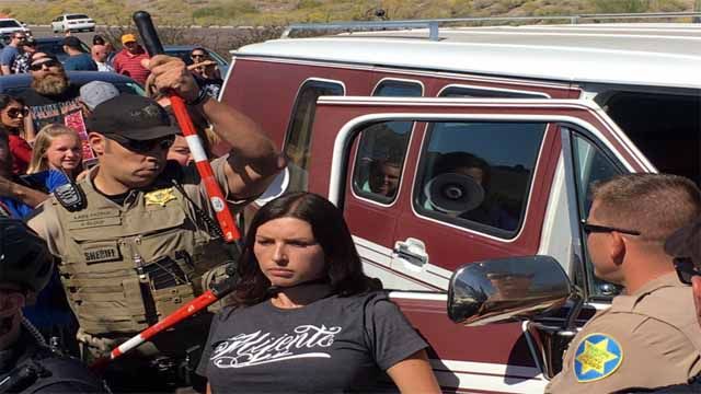 Woman being freed from tied around her car. Unclear if she tied herself or not. (Source: Justin Emerson/Cronkite News)