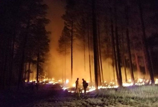 Firefighters often take advantage of cooler and more favorable nighttime weather conditions to create or enlarge the depth of fire line using drip torches. (Source: inciweb)