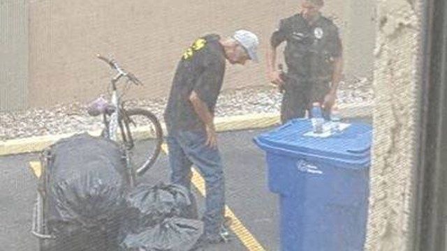 Officer Green gives shoes to man in need. (Source: Mesa Police Dept.)